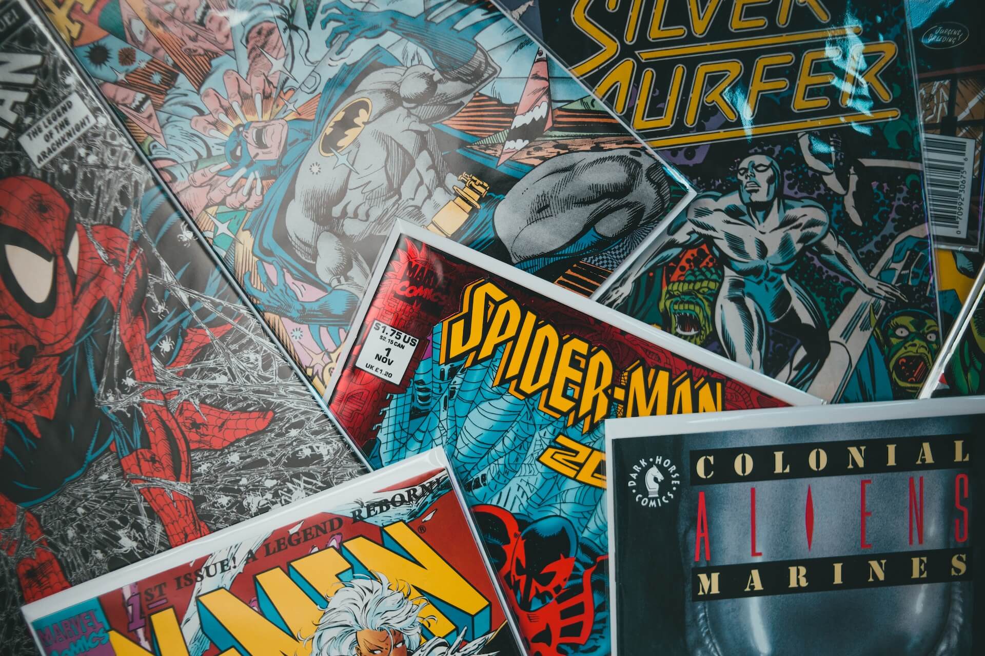 Mesa con una colección de cómics de Marvel y DC, que muestra una variada gama de superhéroes e historias.